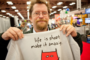 Photo of a Man Showing a Shirt with an Inspiring Quote
